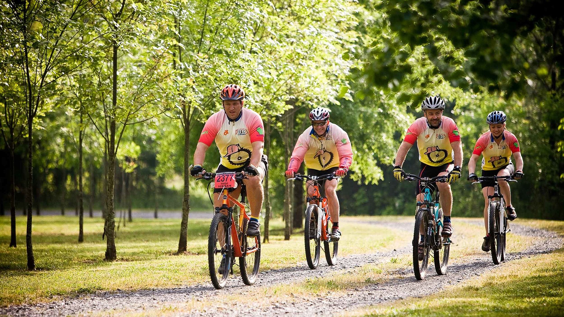 Radfreundliche Unterkünfte im Fichtelgebirge - Gruppe von vier Männern fahren Rad, umgeben von blühenden Bäumen
