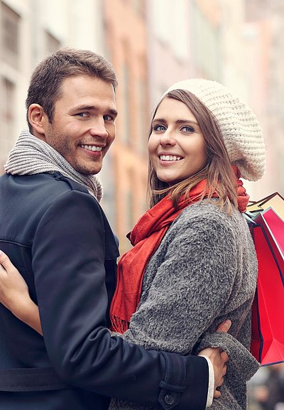 Shopping in Ingolstadt - junges Paar mit Einkaufstüten lächelt in die Kamera