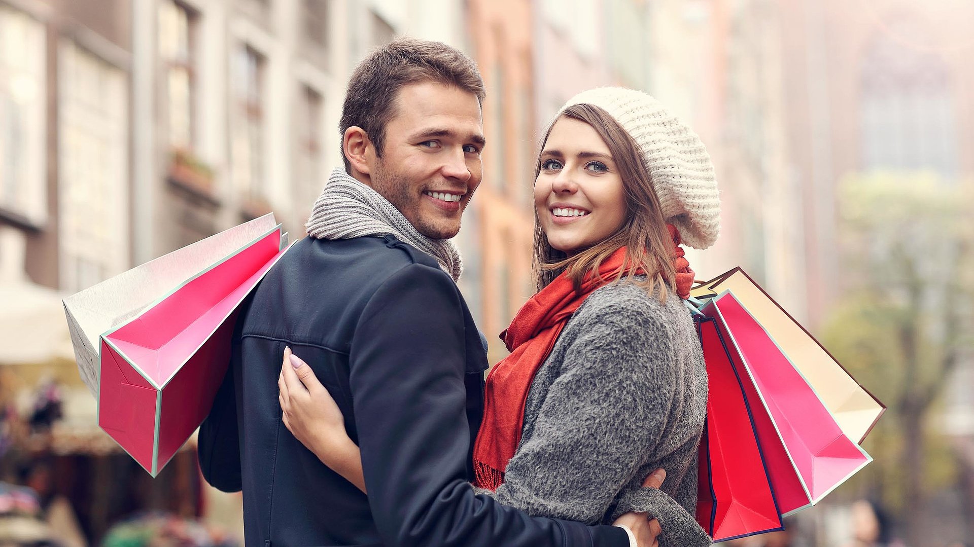Einkaufen in Franken - junges Paar mit Einkaufstüten lächelt in die Kamera