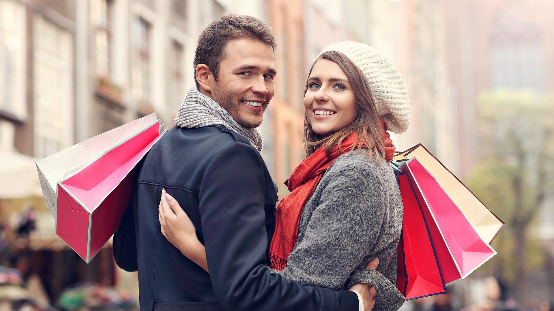 Einkaufen in Unterfranken - junges Paar mit Einkaufstüten lächelt in die Kamera