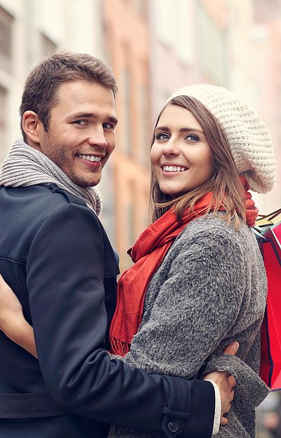 Einkaufen in Nürnberg - junges Paar mit Einkaufstüten lächelt in die Kamera