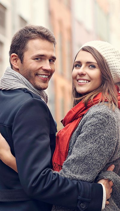Exklusiv Einkaufen im Oberallgäu - junges Paar mit Einkaufstüten lächelt in die Kamera