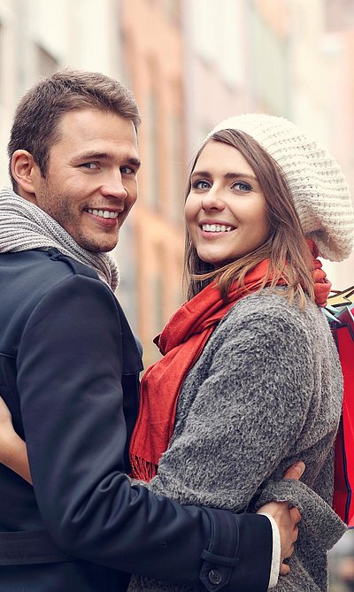 Exklusiv Einkaufen in Franken - junges Paar mit Einkaufstüten lächelt in die Kamera