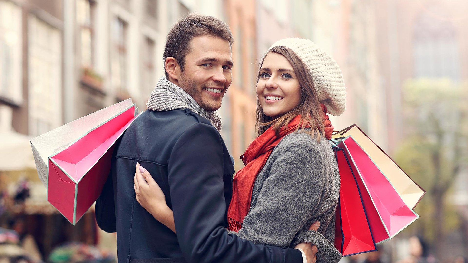 Einkaufen in Oberbayern - junges Paar mit Einkaufstüten lächelt in die Kamera