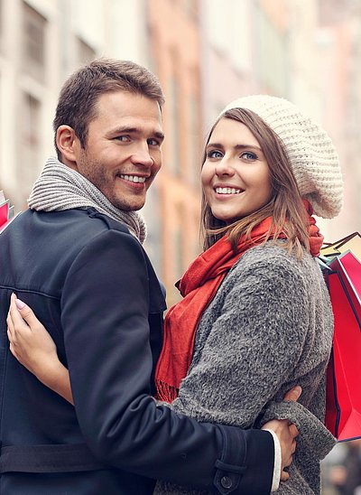 Exklusiv Einkaufen in Mittelfranken - junges Paar mit Einkaufstüten lächelt in die Kamera