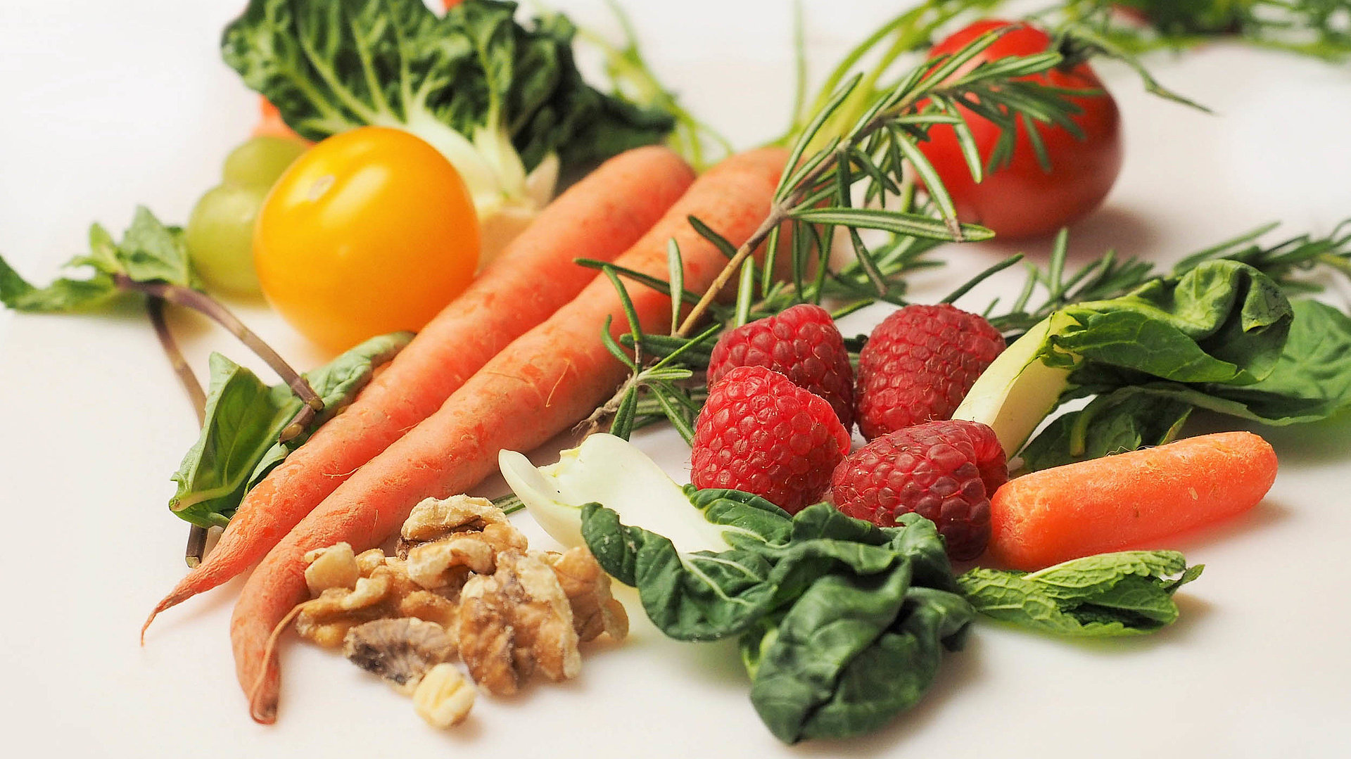 Regionale Erzeugnisse in Nürnberg - Einkaufen mit Regionalem Charme - Tisch gefüllt mit Gemüse wie Karotten, Kopfsalat, Erdbeeren und Walnüssen 