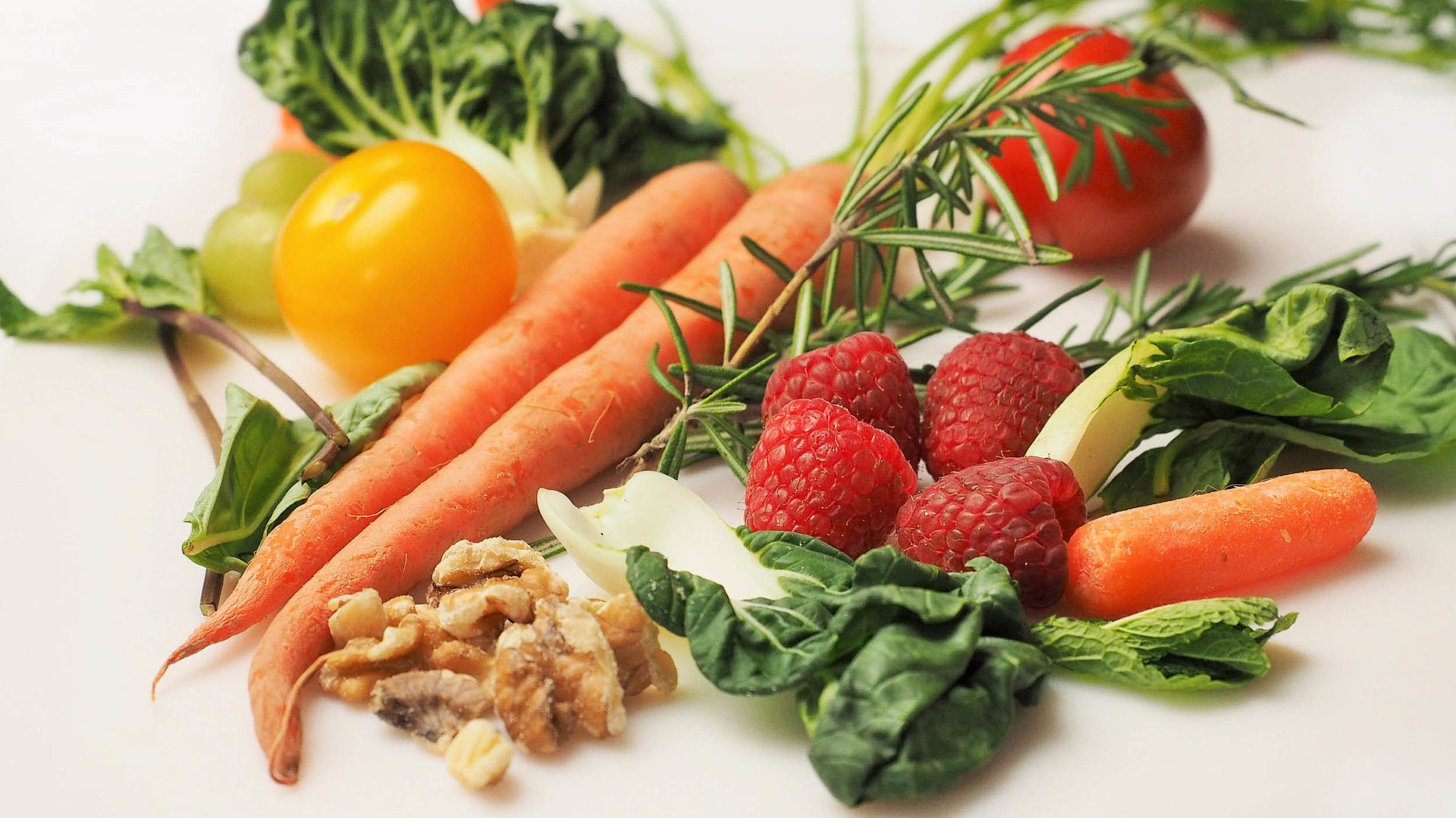 Regionale Erzeugnisse in Franken - Tisch mit Karotten, Erdbeeren, Salatblättern, Tomaten und Walnüssen