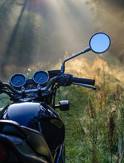 Motorrad-Urlaub in Mittelfranken - schwarzes Motorrad steht in einer Waldlichtung