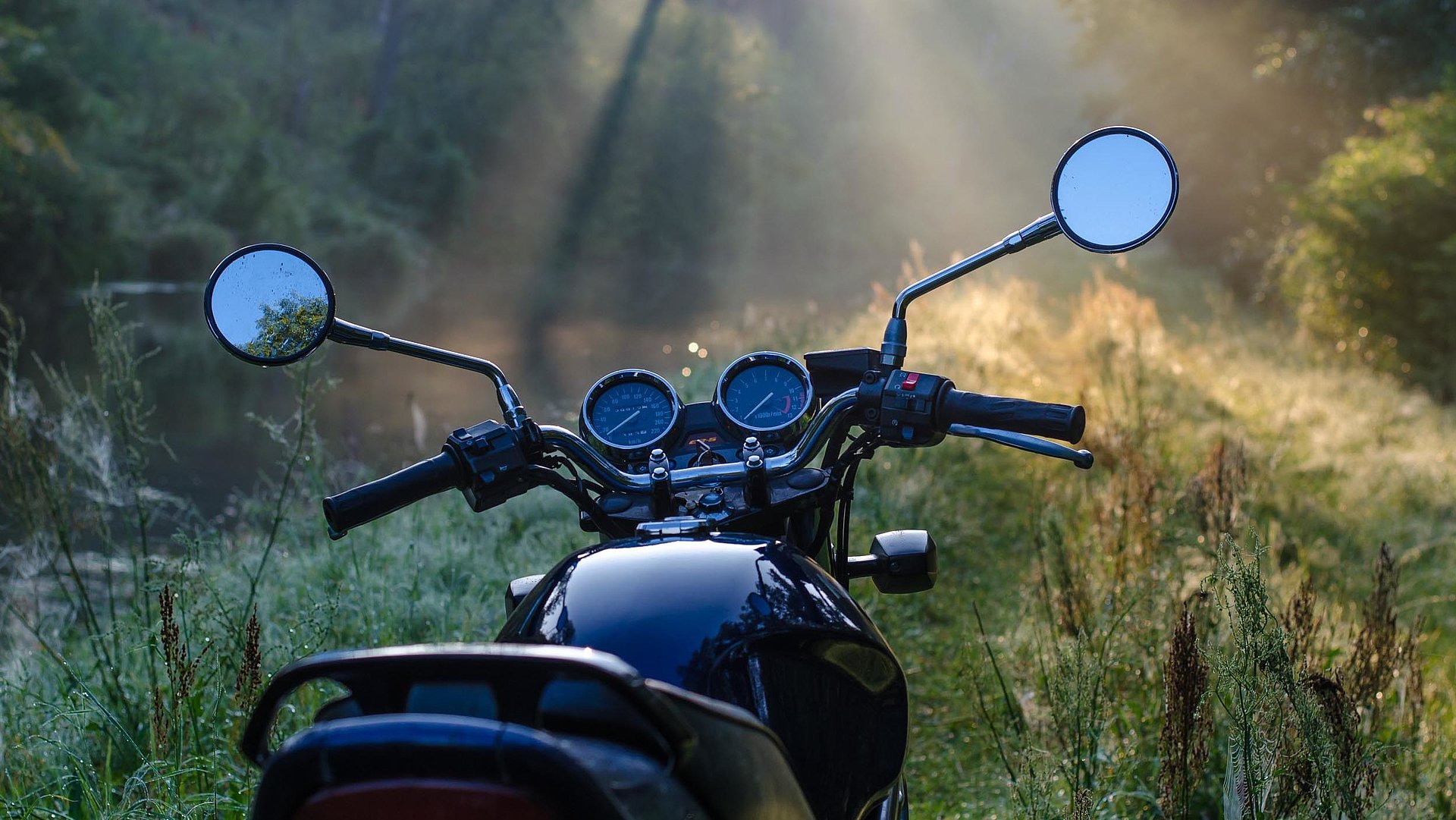 Motorrad-Urlaub in Mittelfranken - schwarzes Motorrad steht in einer Waldlichtung
