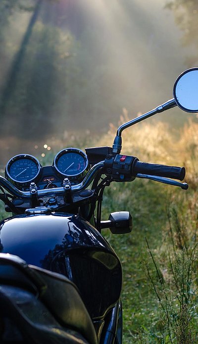 Motorrad-Urlaub im Ostallgäu - schwarzes Motorrad in einer Waldlichtung