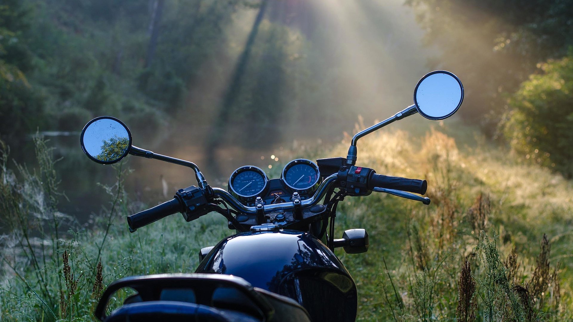 Motorrad-Urlaub in Oberfranken -  schwarzes Motorrad steht in einer Waldlichtung