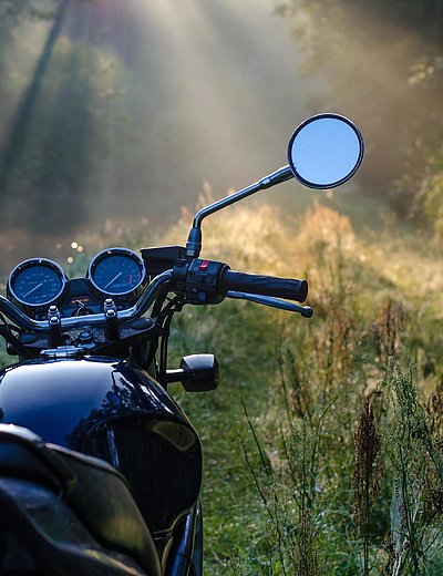 Motorrad-Urlaub in Ostbayern - schwarzes Motorrad in einer Waldlichtung