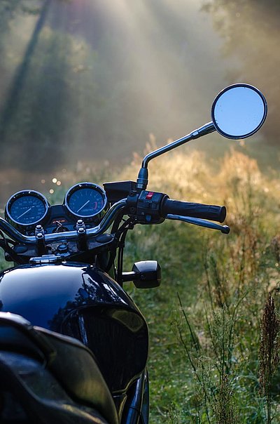 Motorrad-Urlaub in Franken - schwarzes Motorrad in einer Waldlichtung