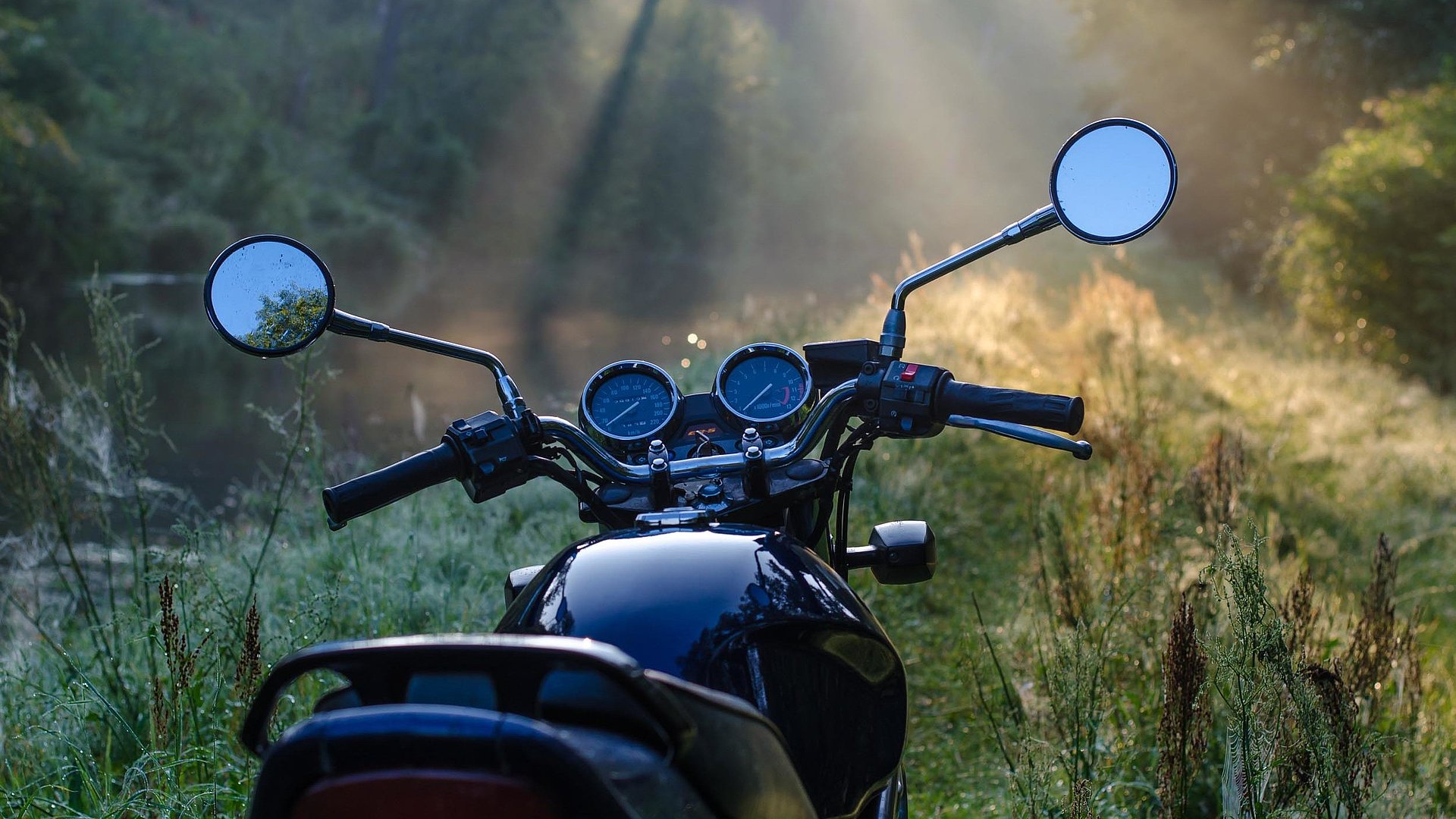 Motorrad-Urlaub im Oberallgäu - Fokus auf dunkles Motorrad in schöner und ruhiger Waldlichtung