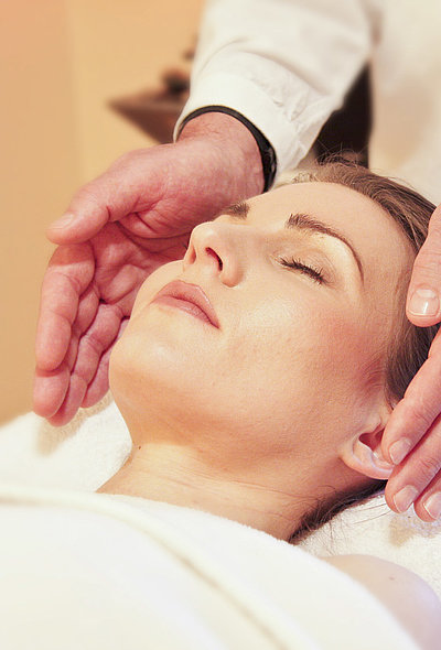 Wellness im Oberallgäu - junge Frau auf einem Massagebett genießt Kopfmassage