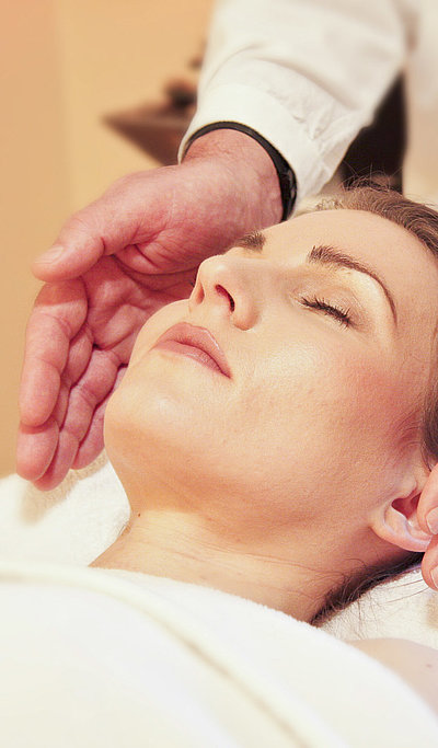 Wellness in Unterfranken - junge Frau auf Massagebett genießt Kopf-Massage