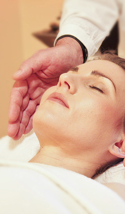 Wellness in Oberfranken - junge Frau auf Massagebett genießt Kopf-Massage