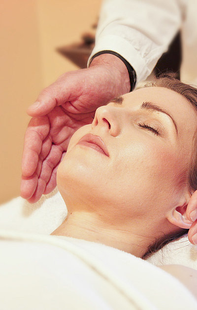 Gesundheitszentren und Kuren im Fichtelgebirge - junge Frau auf einem Massagebett genießt Kopf-Massage 