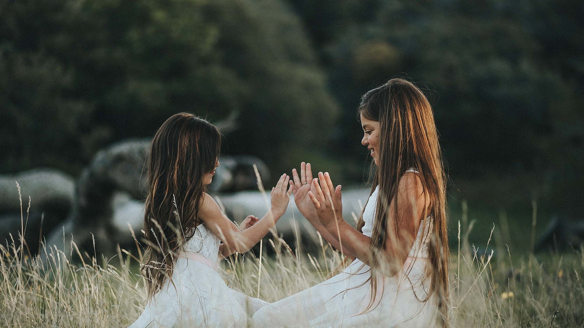 Kinderfreundliche Gastronomie im Ostallgäu - junge Mädchen im weißen Kleid spielen zusammen auf einem Feld