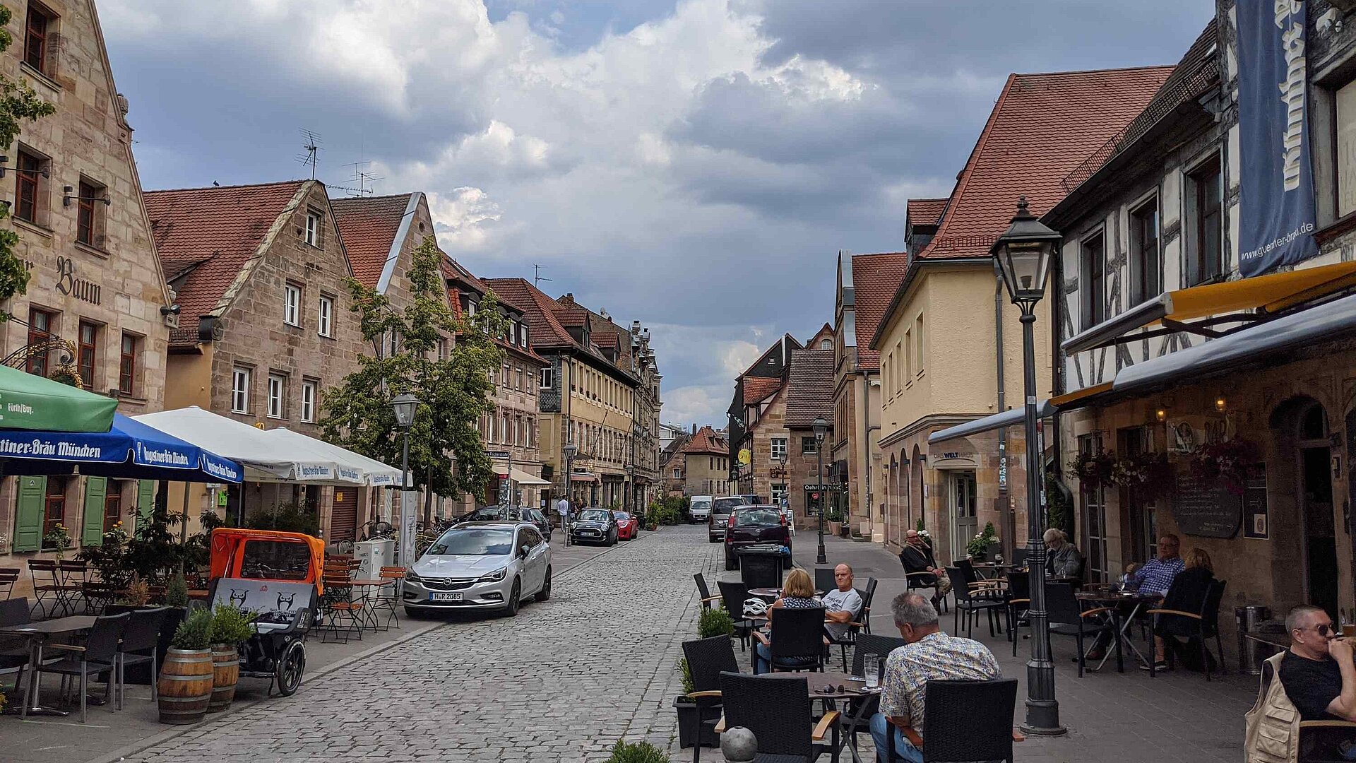 Die Gustavstrasse in Fuerth mit Sonnenschirmen und Gaesten an Tischen