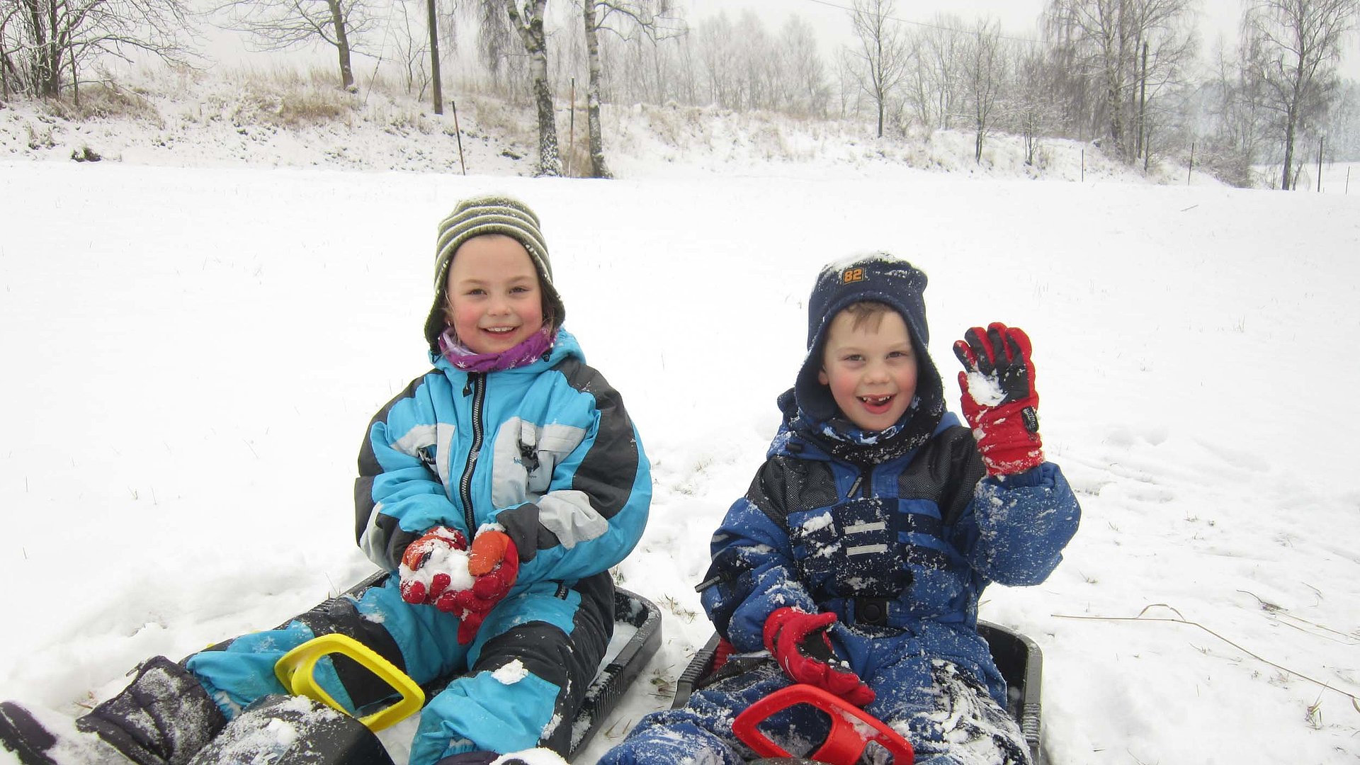 Kinderfreundliche Angebote im Fichtelgebirge - Jungs, Kleinkinder sitzen im Schnee auf einem Schlitten
