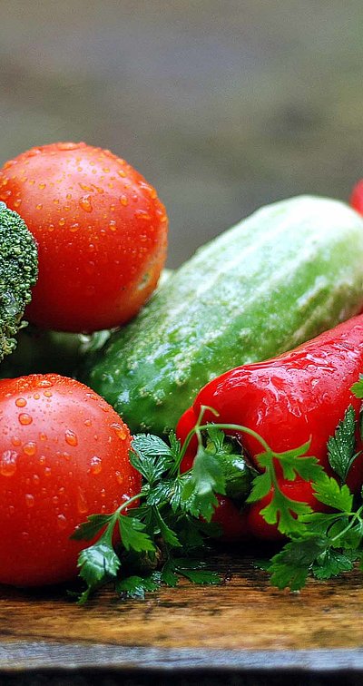 Regionale Erzeugnisse in Unterfranken - Gurken, Brokkoli, Tomaten und Chilli auf Holztisch