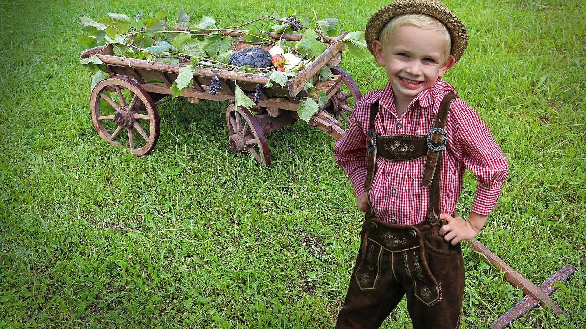 Kinderfreundliche Angebote in Nürnberg - Erlebnisse für die gesamte Familie -kleiner Junge in traditionell bayerischer Kleidung steht auf einer Wiese