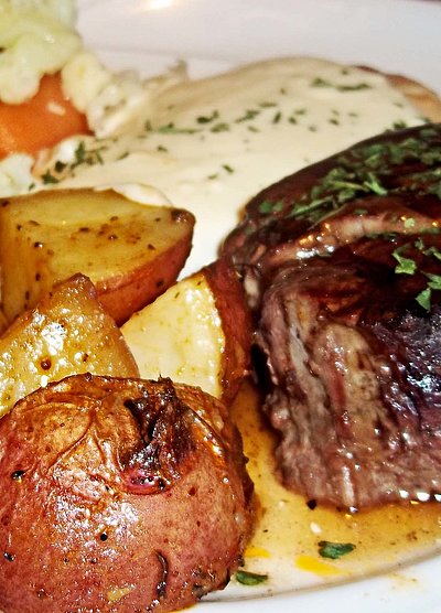 Steak Essen in Unterfranken - Teller gefüllt mit frischem Rinder-Steak, Kräuterbutter, gebratenen Kartoffeln und Salat