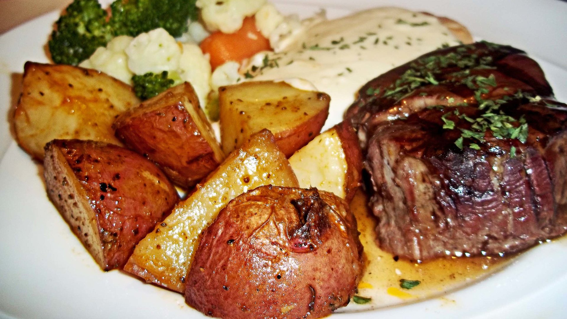 Steak essen in der Fränkischen Schweiz - Teller gefüllt mit, u.a., saftigem Steak und gebratenen Kartoffeln