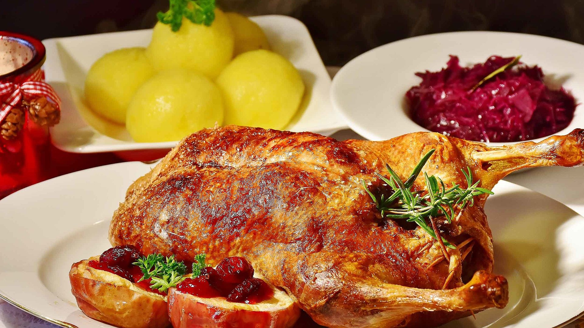 Gehobene Küche in Nürnberg - Fokus auf Teller mit Ente und separaten Tellern jeweils mit Knödel und Rotkohl