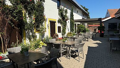Gelebte Gastfreundschaft: Der Landgasthof Krug in Dechendorf - ein Blick in den Biergarten mit Tischen und Stühlen