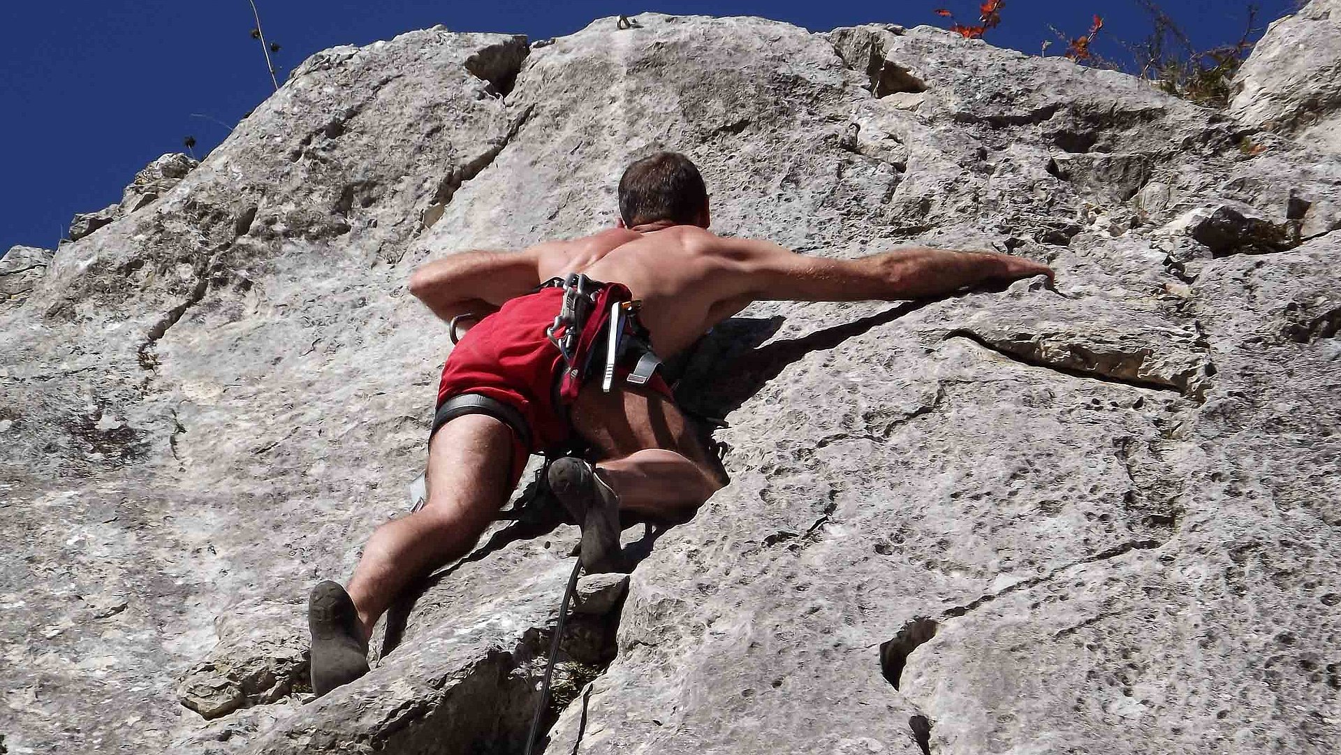Outdoor-Freizeitangebote in Oberbayern - Mann klettert einen Felsen hoch