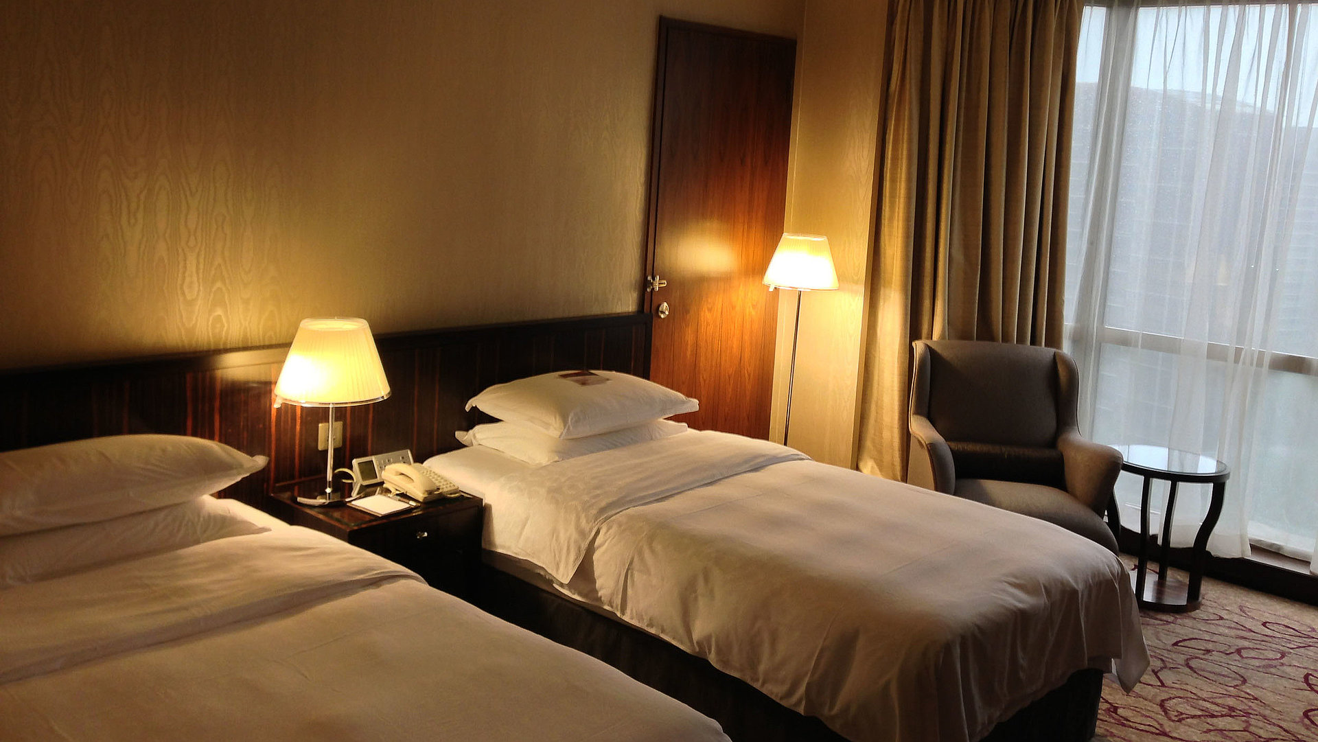 Pauschalangebote Unterkunft in Kempten im Allgäu - sehr ordentliches Hotelzimmer mit zwei Betten, warmer Nachtlampe und Gardinen