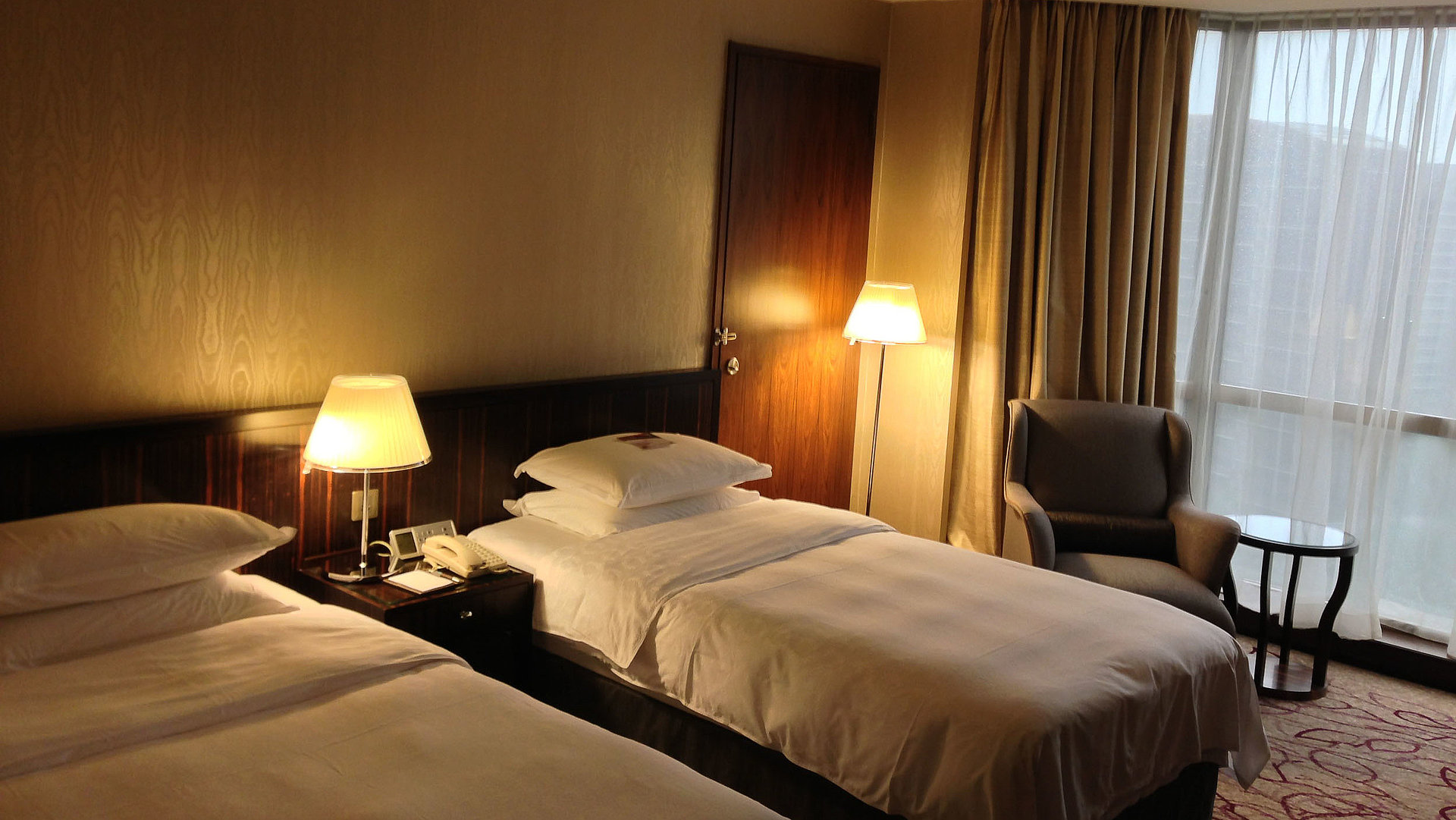 Übernachten Video in Oberbayern - sehr ordentliches Hotelzimmer mit zwei Betten, warmer Nachtlampe und Gardinen