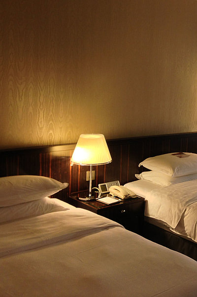 Unterkunft in Unterfranken - sehr ordentliches Hotelzimmer mit zwei Betten, warmer Nachtlampe und Gardinen