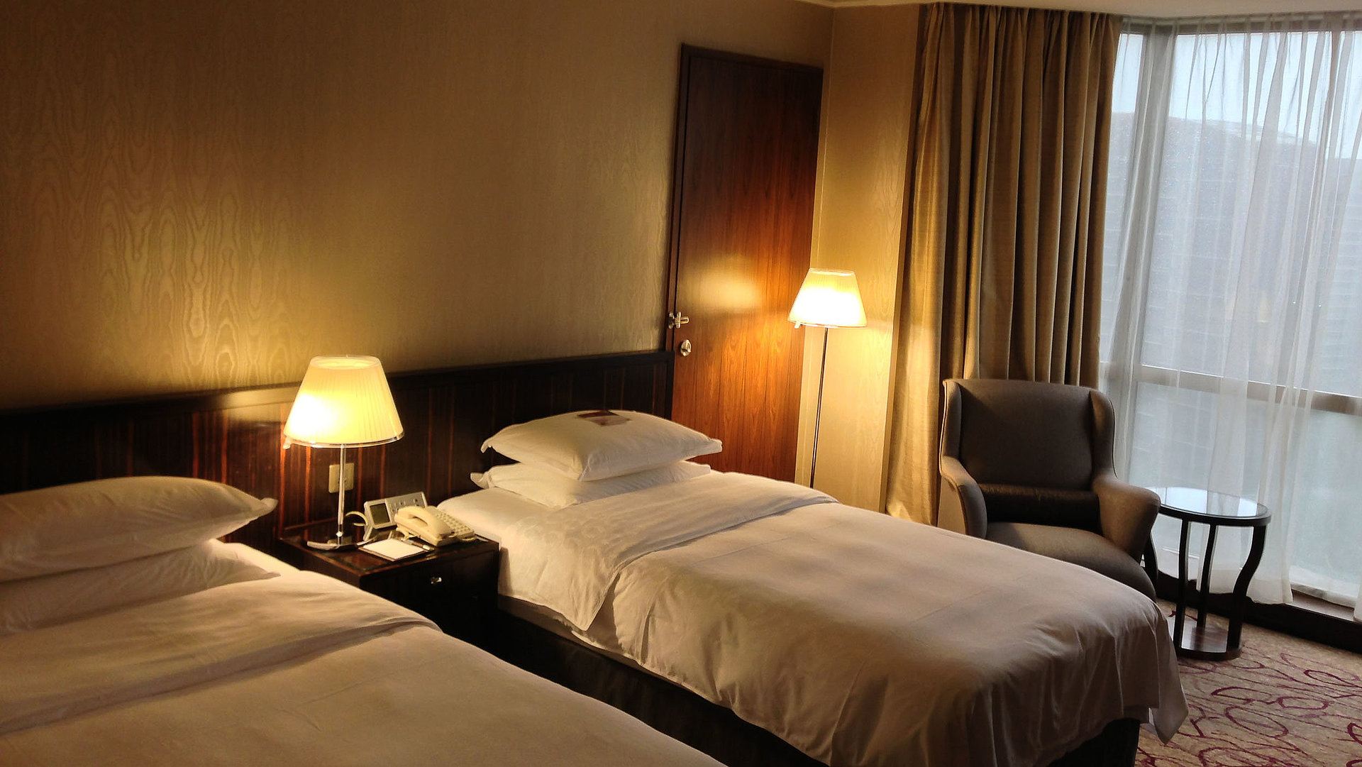 Unterkunft im Ostallgäu - sehr ordentliches Hotelzimmer mit zwei Betten, warmer Nachtlampe und Gardinen