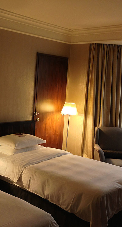 Hotels für Gruppen in Ostbayern -  sehr ordentliches Hotelzimmer mit zwei Betten, warmer Nachtlampe und Gardinen