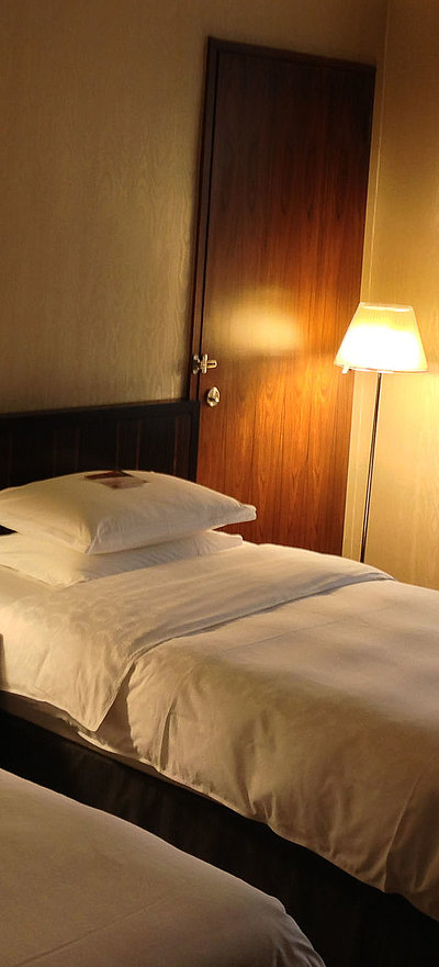 Pauschalen für Wochentage in Oberfranken - sehr ordentliches Hotelzimmer mit zwei Betten, warmer Nachtlampe und Gardinen