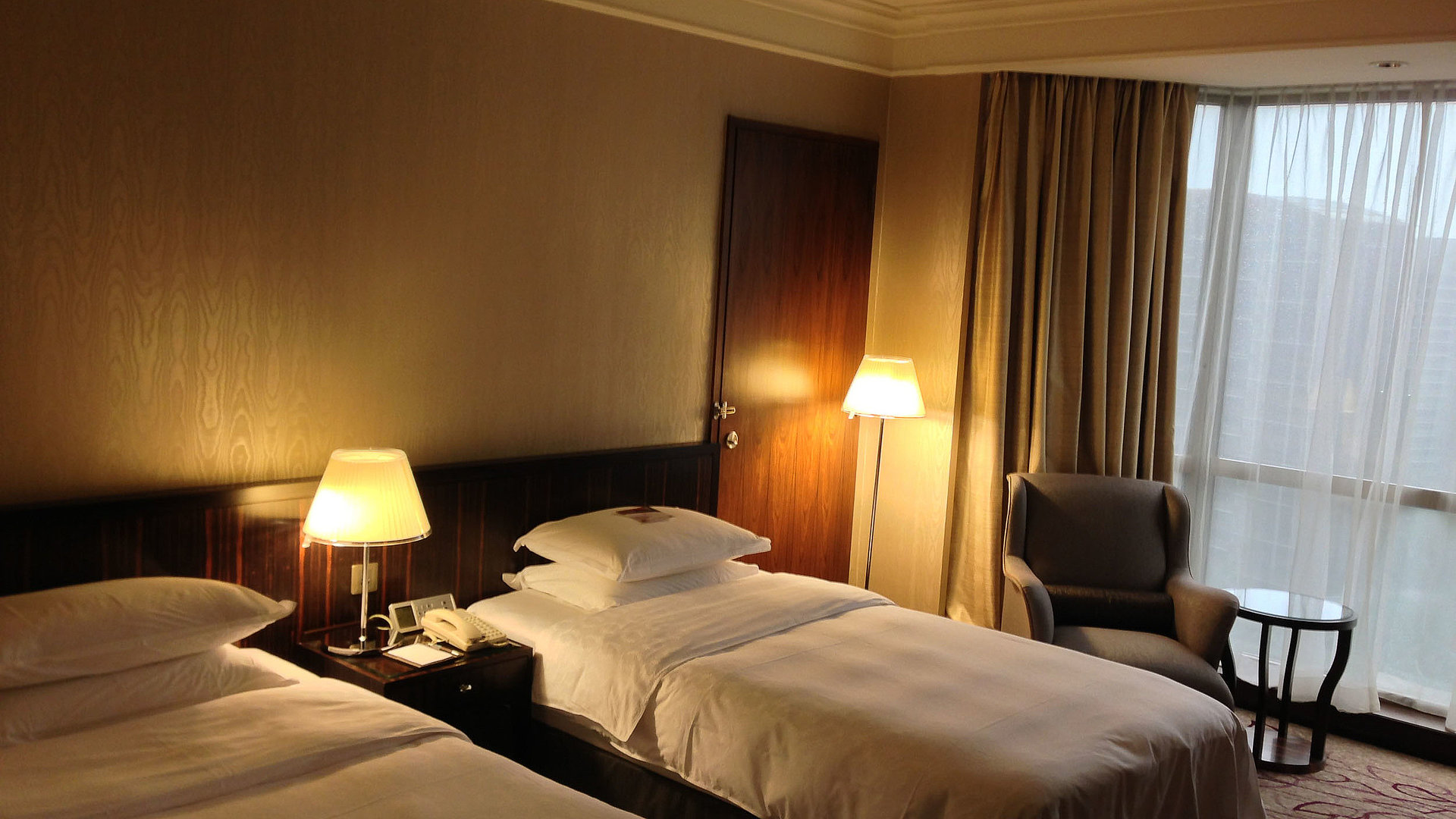 Hotels für Gruppen in Nürnberg - sehr ordentliches Hotelzimmer mit zwei Betten, warmer Nachtlampe und Gardinen
