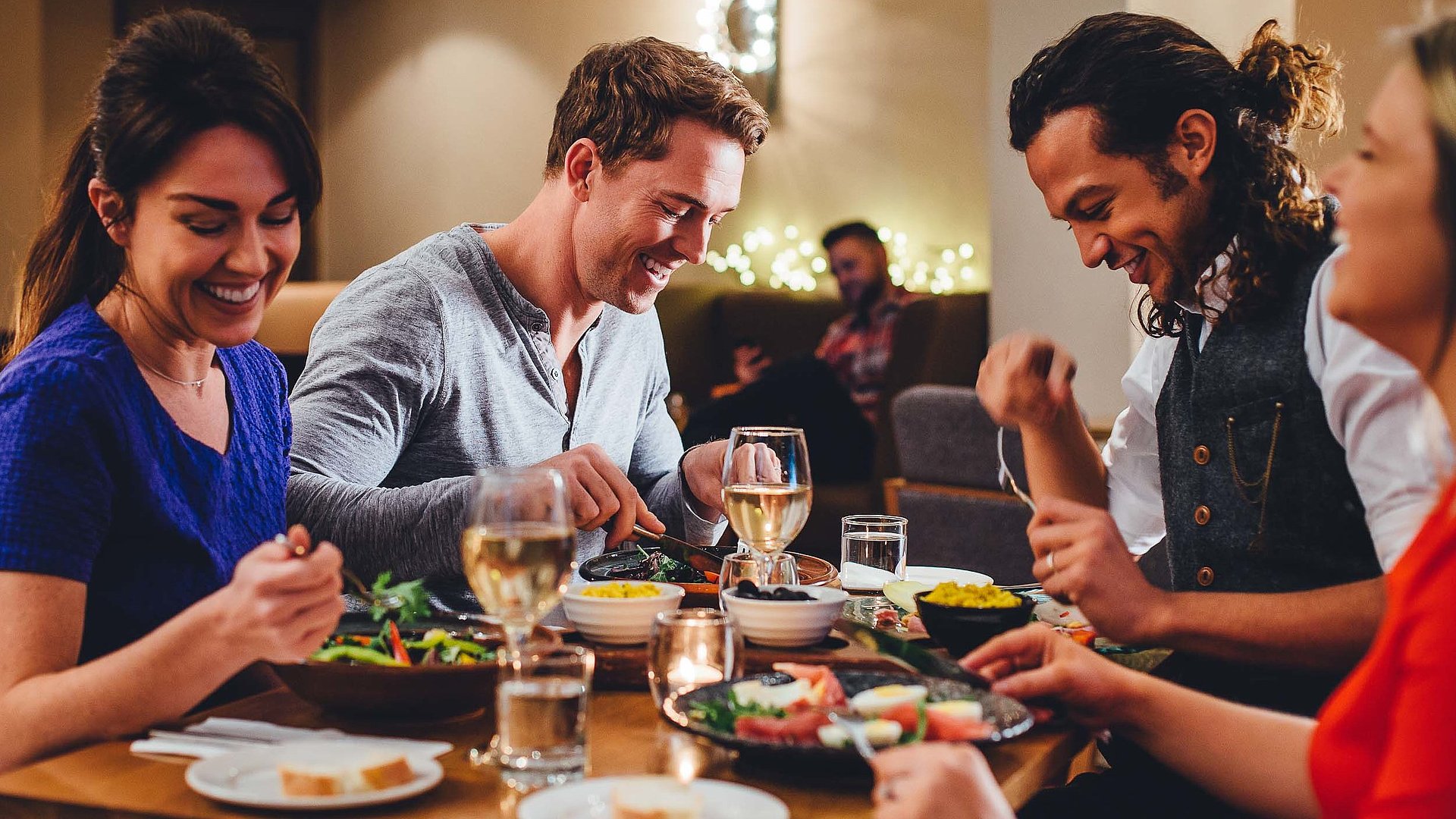 Abendessen in Oberfranken - eine Gruppe von Gästen lacht zusammen an einem bedeckten Tisch