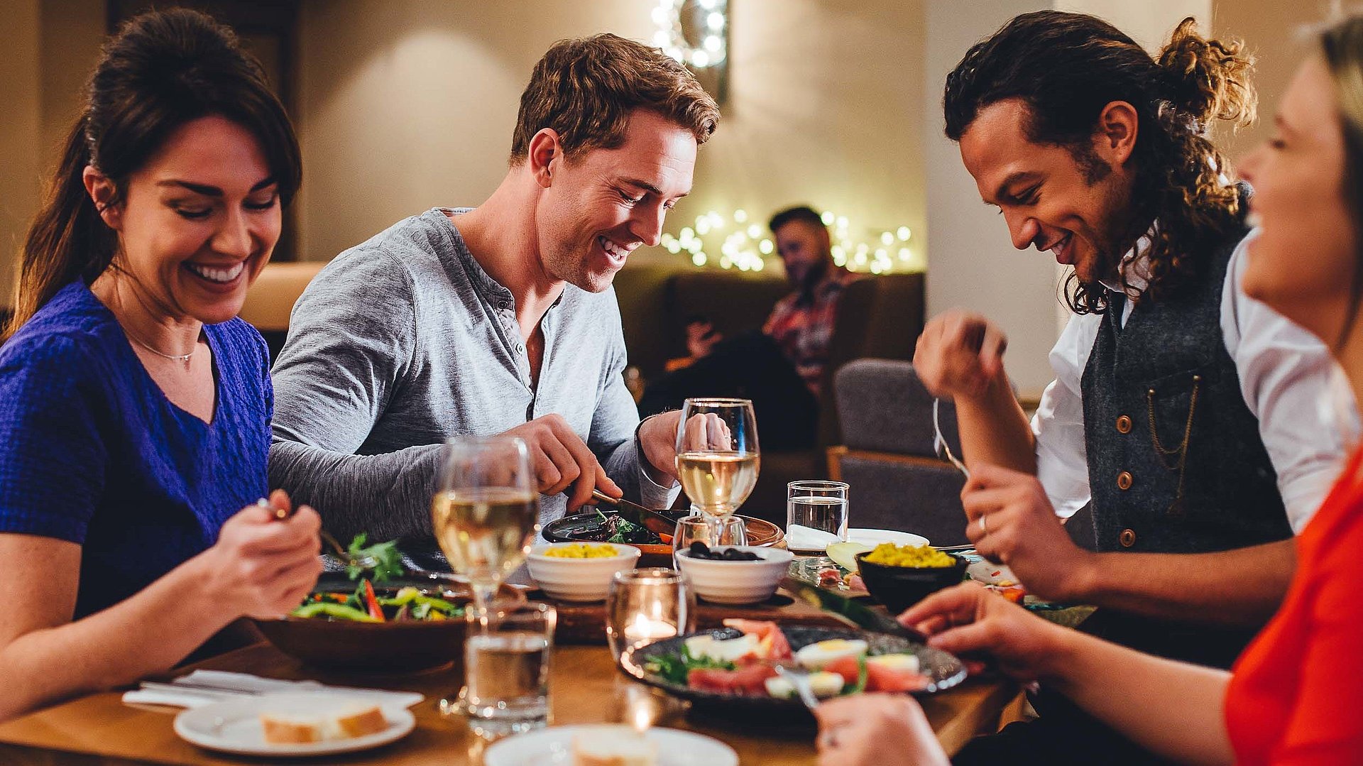 Gastronomie für Gruppen in Franken - eine Gruppe von Gästen lacht zusammen an einem bedeckten Tisch