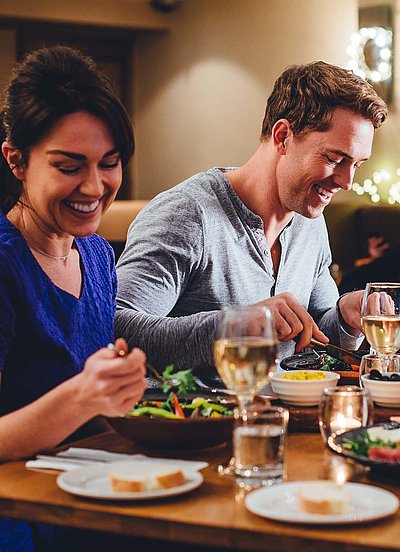 Gastronomie in Franken - eine Gruppe von Gästen lacht zusammen an einem bedeckten Tisch