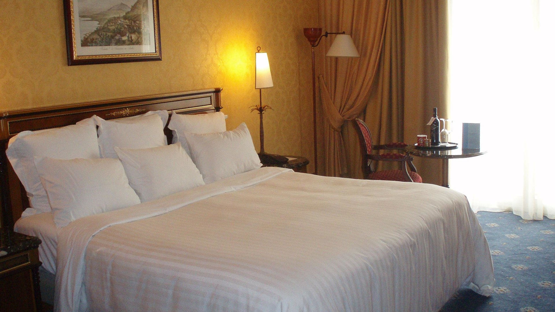 Unterkunft in Kempten im Allgäu - sehr ordentliches Hotelzimmer mit großem Bett, warmer Nachtlampe und mittelgroßem Wandgemälde