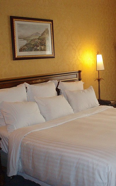 Pauschalangebote für eine Woche Unterkunft im Oberallgäu - sehr ordentliches Hotelzimmer mit großem Bett, warmer Nachtlampe und Wandgemälde 