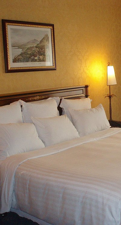 Pensionen und Gasthöfe für Gruppen in Franken - sehr ordentliches Hotelzimmer mit großem Bett, warmer Nachtlampe und mittelgroßem Wandgemälde 