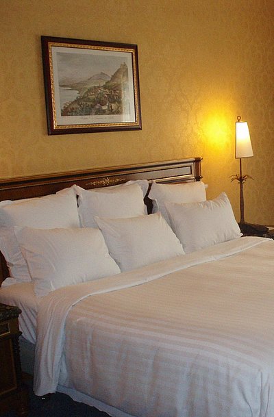Unterkunft für Geschäftsreisende in Ostbayern - sehr ordentliches Hotelzimmer mit großem Bett, warmer Nachtlampe und mittelgroßem Wandgemälde