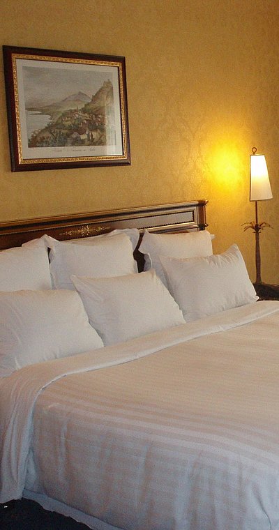 Pauschalen für Wochentage in Unterfranken - sehr ordentliches Hotelzimmer mit großem Bett, warmer Nachtlampe und mittelgroßem Wandgemälde