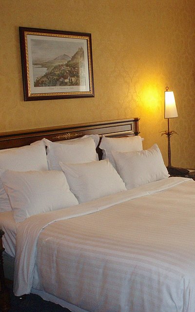 Hotels für Gruppen im Oberallgäu - sehr ordentliches Hotelzimmer mit großem Bett, warmer Nachtlampe und Wandgemälde