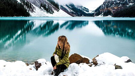 5 Tipps für die kalte Jahreszeit - Frau sitzt am See