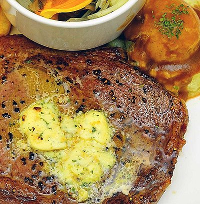 Steak Essen in Oberbayern - Teller gefüllt mit Steak, Salat und Pommes